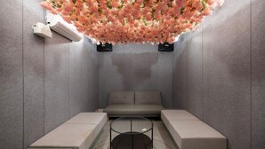 A modern spa room with a grey sofa, a glass coffee table, and a ceiling adorned with pink flowers. - Cheongju Hotel Dictionary (Cheongju)