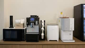 Una cafetera, un microondas y un refrigerador sobre una encimera.