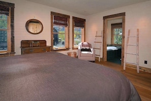 A bedroom with a large bed, two windows with wooden frames, a dresser, a chair, and a ladder leaning against the wall. - Elk Ave Luxury, Gorgeous 3+ BR Custom Home in CB (Crested Butte)