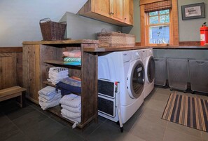 A laundry room with a washing machine, stacked towels, and baskets on shelves. - Elk Ave Luxury, Gorgeous 3+ BR Custom Home in CB (Crested Butte)