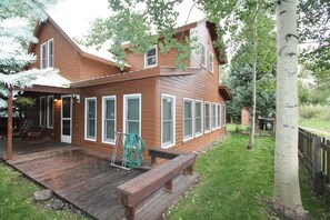A two-story wooden house with a deck, large windows, and a fenced yard. - 1st St, Wonderful 3 BR home in the town of CB! (Crested Butte)