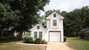 A two-story house with a garage, surrounded by trees and a well-maintained lawn. - Culberhouse Cottage - Executive/Vacation Rental (Jonesboro)