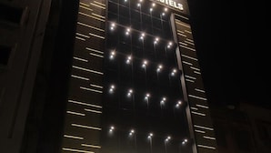 Um hotel com uma placa grande para Grand Geet Hotels e um restaurante chamado Khidmat Restaurant.