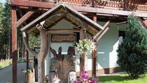 A wooden structure with a sign reading "Jägersruh" and a bench with flowers. - Retreat with Sauna, Hot Tub (Jägersgrün)