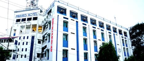 A multi-story building with a sign for 'Prayag Hotel' and 'Prayag Training Institute'.