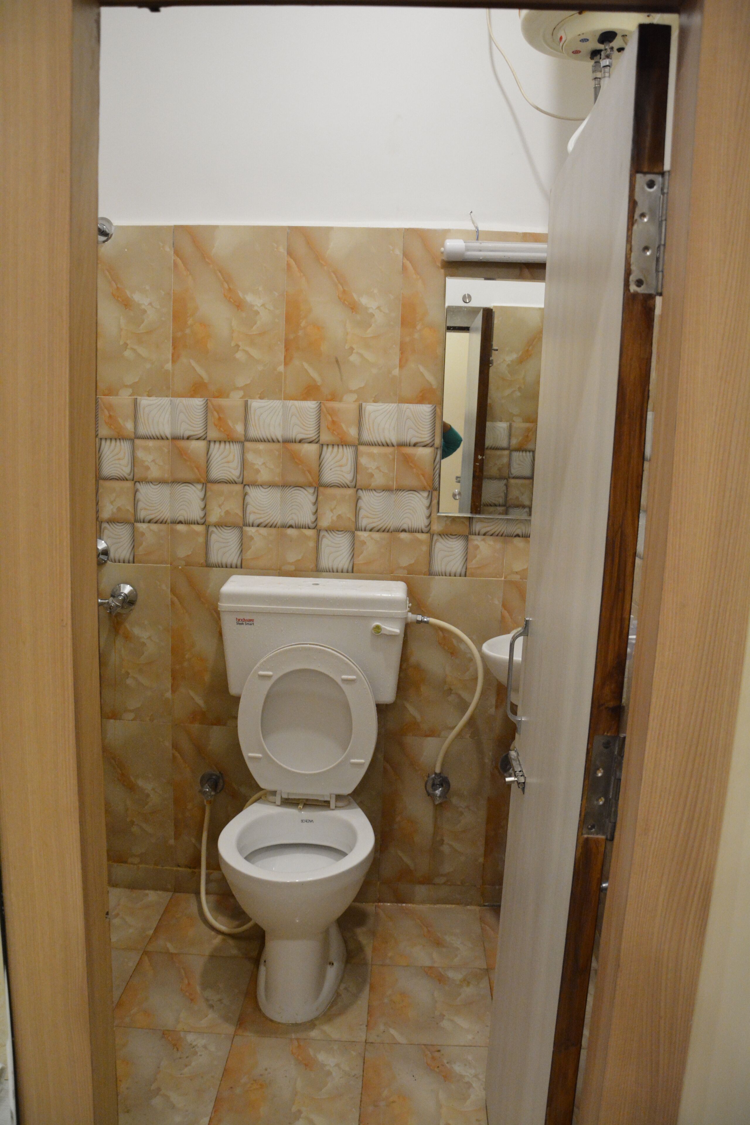 A small bathroom with a toilet, a shower, and a mirror.