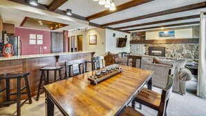 Ein gemütliches Interieur mit einem Holztisch, Barhocker, einem Kamin und einem Fernseher.