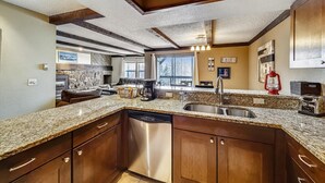 Eine moderne Küche mit Granit-Arbeitsplatten, Edelstahlgeräten und Holzschränken.