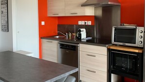 A modern kitchen with a dishwasher, a microwave, and a built-in oven. - Central Apartment in Biscarrosse - 4 Guests, Close to Beaches, Surf Classes, Parking & Wifi Included (Biscarrosse)
