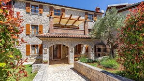 A stone building with a balcony, a covered patio, and a stone pathway leading to the entrance. - 4 bedroom pet friendly home in Medulin (Medulin)