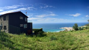Ein Haus mit einer Steinfassade, einem Balkon und Blick aufs Meer.