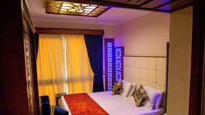 Ein Hotelzimmer mit Bett, Stuhl, Tisch und einer Zierwand.