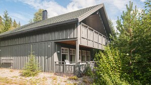 A two-story wooden cabin with a balcony, surrounded by trees. - Gorgeous home in Søre Osen with WiFi (Søre Osen)
