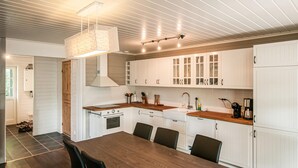 A modern kitchen with white cabinetry, a wooden countertop, and a hanging light fixture. - Gorgeous home in Søre Osen with WiFi (Søre Osen)