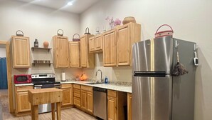 Una cocina moderna con armarios de madera, electrodomésticos de acero inoxidable y una encimera de granito.