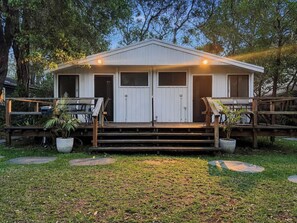 A two-story building with a porch, a garage, and a small deck area.
