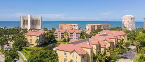 A coastal resort with multiple hotel buildings, a marina, and a clear view of the ocean.