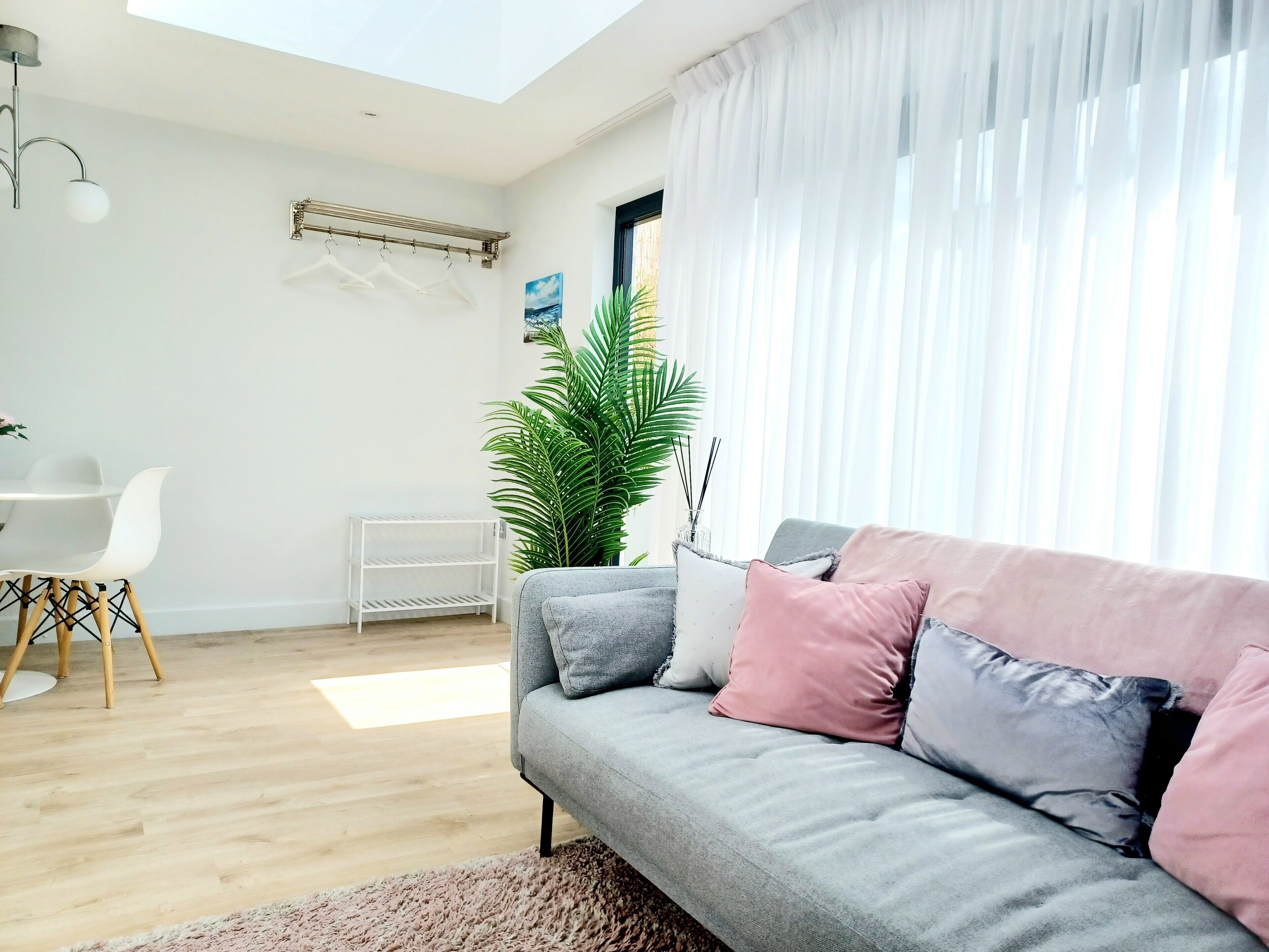 A modern living room with a grey sofa, a small table, and a plant.