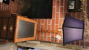 A room with a brick wall, a wooden cabinet with brass handles, a blackboard, and a purple object. - 15 minutes from Base (Pemberton)