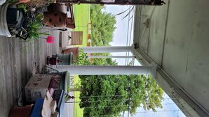 A covered outdoor area with a wooden floor, various potted plants, and a green chair. - 15 minutes from Base (Pemberton)