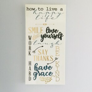 A motivational poster with phrases like "how to live a happy life," "SMILE," "love yourself," "WORK," "LAUGH," "SAY THANKS," "BE KIND," and "have GRACE."