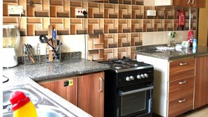 Una cucina con mobili in legno, un piano di lavoro in granito, un forno e una lavastoviglie.
