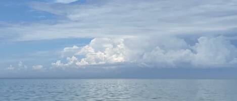Une mer calme sous un ciel nuageux.