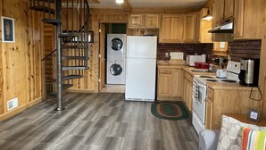 Una cocina compacta con armarios de madera, lavadora incorporada, refrigerador y estufa.