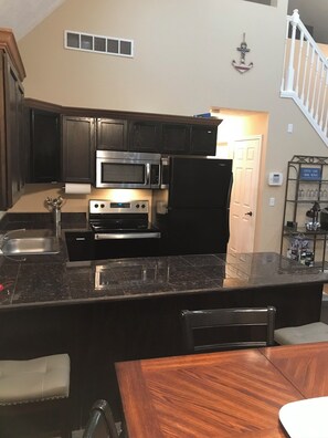 Enjoy cooking in this well-equipped kitchen with a central island, oven, and microwave.