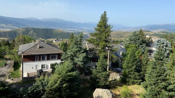 A house surrounded by trees and mountains in the background. - Apartment in residence with superb view and parking (Font-Romeu-Odeillo-Via)