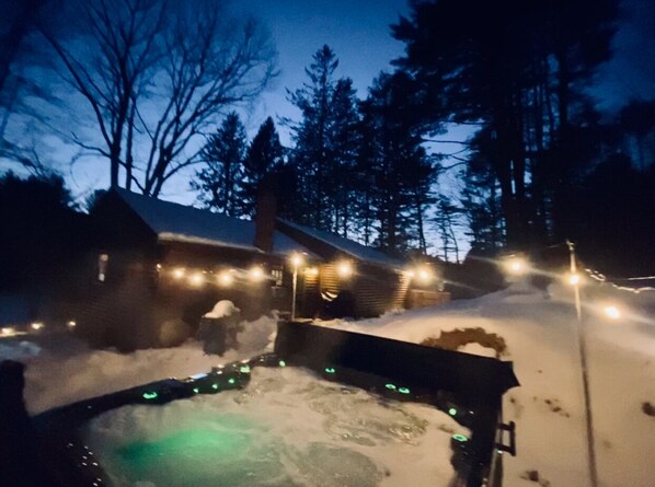 Relax in a hot tub surrounded by serene winter scenery.
