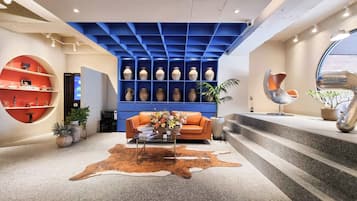 Un interior moderno con techo azul, sofá de cuero, una mesa de centro y alfombra de piel de vaca.