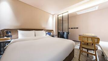 Habitación de hotel con una cama grande, un escritorio con silla, un espejo y un aire acondicionado de pared.