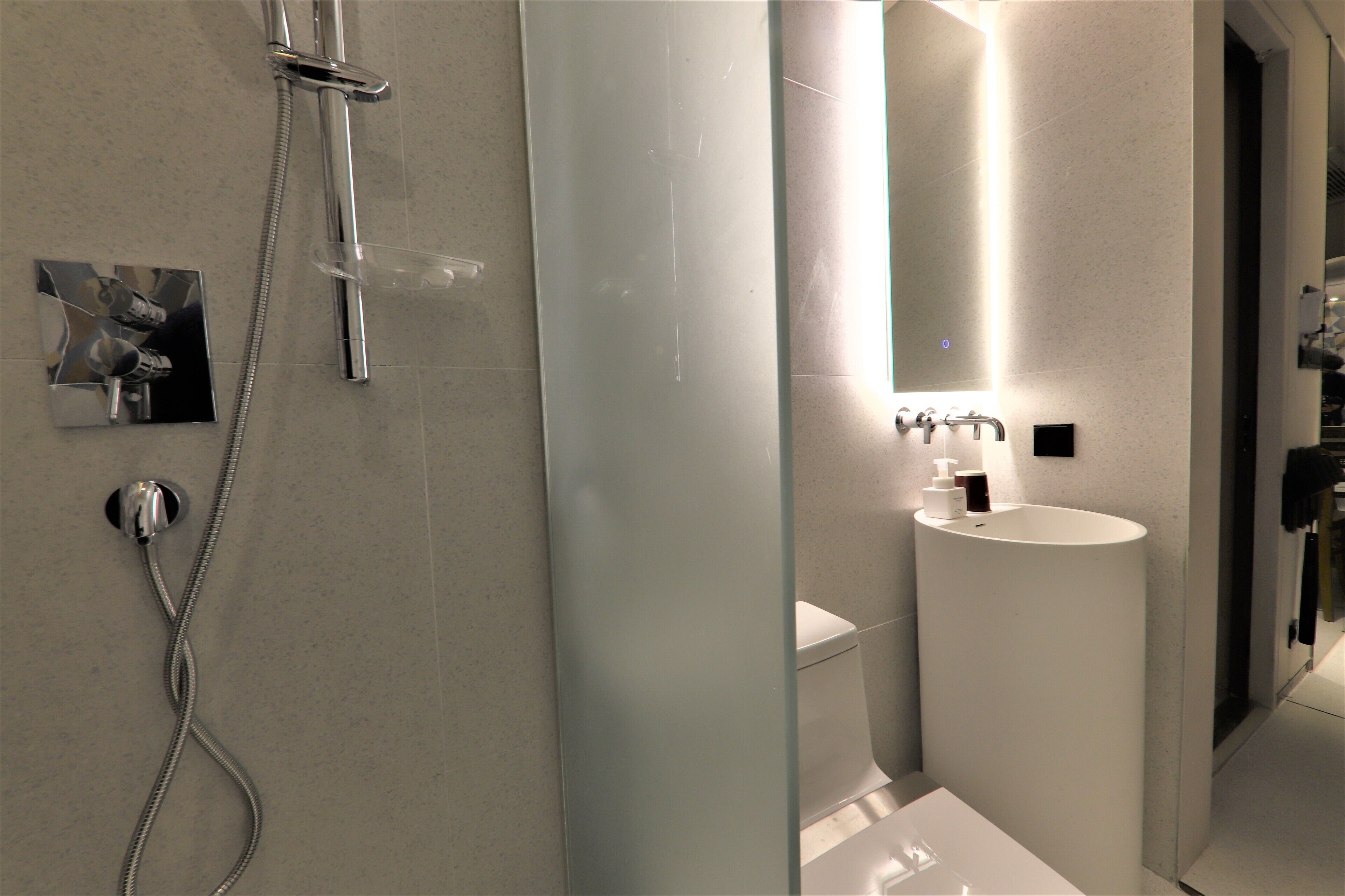 Un baño moderno con cabina de ducha de vidrio, inodoro y lavamanos.