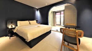 Een moderne hotelkamer met een groot bed, een bureau en een stoel.