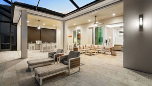 A spacious indoor area with a modern design, featuring a dining area, seating arrangements, and a kitchen. - Intervillas Florida - Villa Leonardo (Cape Coral)