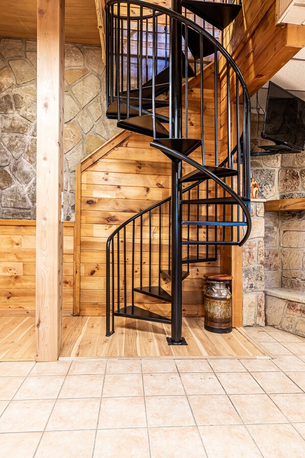 A spiral staircase with a wooden interior and stone walls.