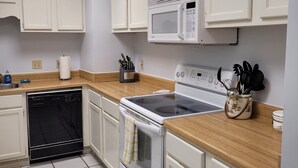 A kitchen with white cabinets, a microwave, a stove, and a dishwasher. - Ready to Enjoy BILOXI!! (Biloxi)