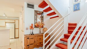 A staircase with red carpeted steps and white railings, leading to an upper floor. - Cozy Condo! New low rates for Spring/Summer 2026! Pet Friendly! (Tucson)