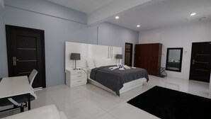 Ein modernes Schlafzimmer mit Bett, Nachttischen, Schreibtisch und Stuhl.