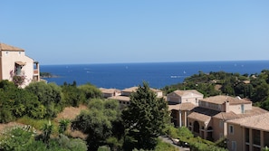 A coastal view with buildings and a clear blue sea.
