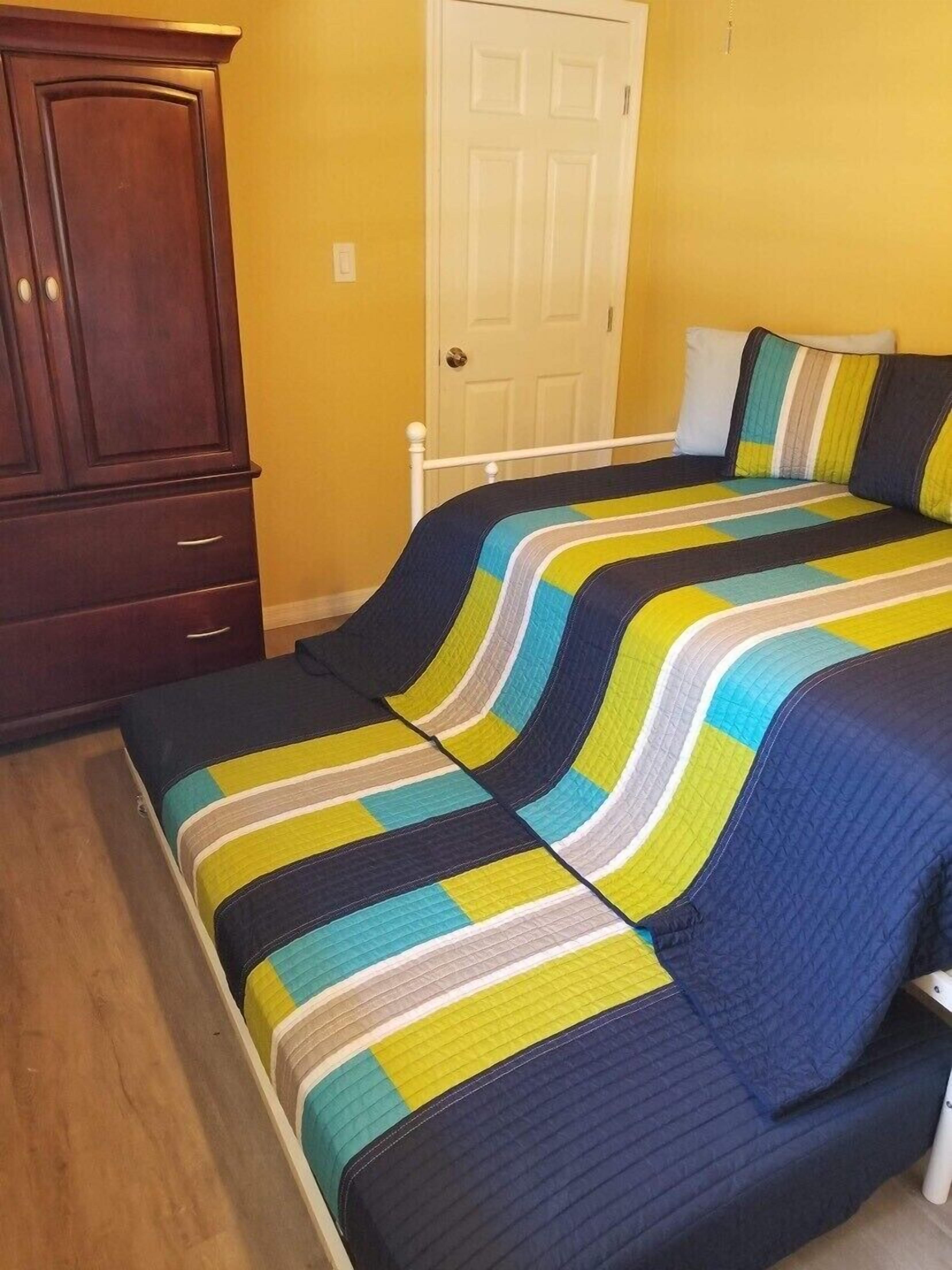 A bedroom with a bed, a wardrobe, and a door.