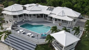 A multi-level house with a large central pool, multiple balconies, and a covered patio area. - Luxury 5BD Villa - Massive Pool & Outdoor Vibe (Gros Islet)