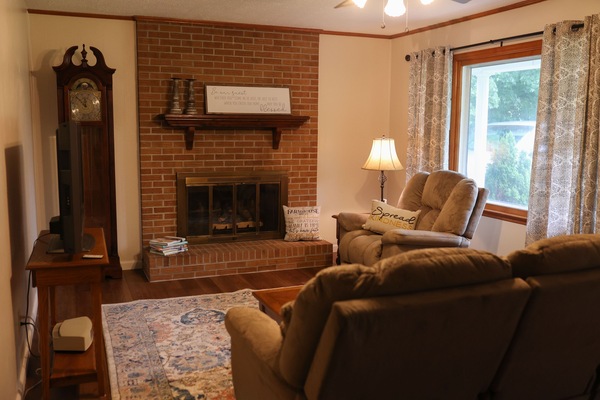 Living room with large bay window and gas logs