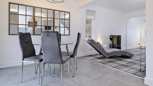 A modern living room with a dining area, a fireplace, and a large mirror on the wall. - Contemporary HIGHLAND HOUSE close to town and Ben Nevis (Fort William)