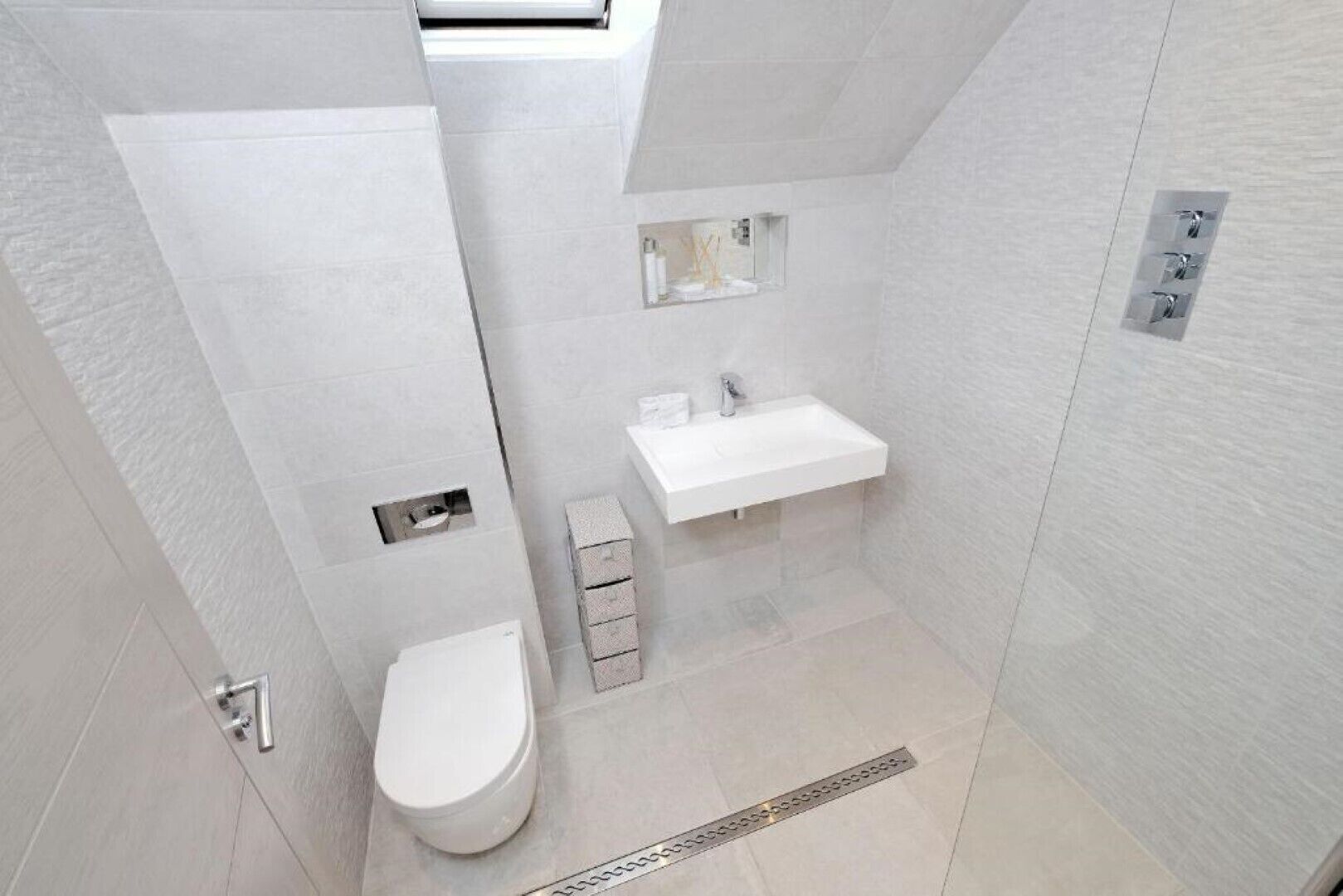 Ein modernes Badezimmer mit Toilette, Waschbecken und Dusche.