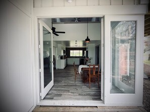 An open doorway leading to a dining area with a wooden floor, a table with chairs, and a ceiling fan. - Country Living with all the Amenities (Lockhart)