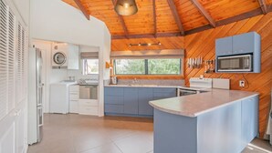 Eine moderne Küche mit Kochinsel, eingebauten Geräten und Holzboden.