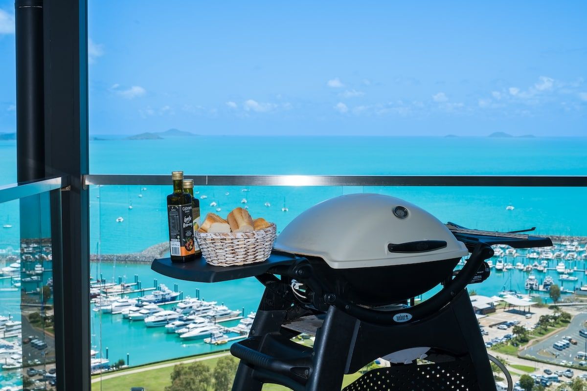 A balcony with a view of a marina and the sea.