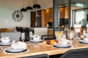 Una mesa de comedor dispuesta con platos, vasos y un centro de mesa.